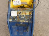 a blue and yellow machine sitting in the middle of the street