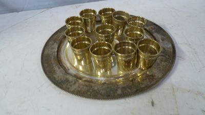 un plateau en argent posé sur une table, sur lequel se trouvent des tasses