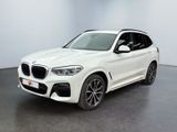 a white bmw suv parked in a showroom