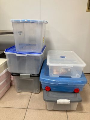 trois boîtes de rangement en plastique posées les unes à côté des autres sur le sol