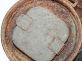 a close up view of a rusted metal container with a piece of cement in it