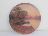 a plate with a painting of a boat on the water