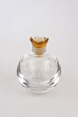 une petite bouteille en verre transparent avec un bouchon doré