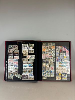 an open book with stamps on it sitting on top of a table