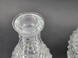 two clear glass vases sitting next to each other on a table