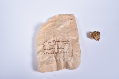 un bout de papier sur lequel il y a quelque chose d'écrit, à côté d'un morceau d'or