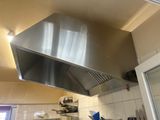 a stainless steel hood in the kitchen above the stove