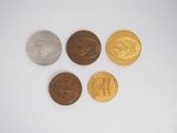 four different types of coins sitting on top of a white surface