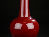 red vase on stand against a black background with a black background