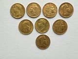 a bunch of gold coins sitting on top of a white surface
