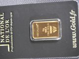 the gold bar is sitting on top of the card on the table
