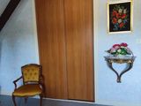 a chair in the corner of a room with a painting on the wall