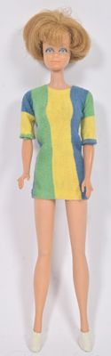 poupée Barbie aux cheveux blonds, vêtue d'une robe multicolore et de chaussures blanches