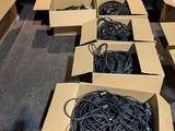 Plusieurs cartons contenant des câbles sont alignés dans une pièce