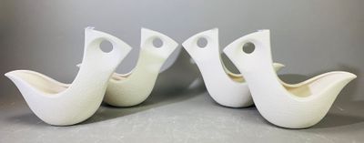 trois oiseaux en céramique blanche sont posés sur une surface grise