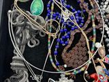 a black box filled with assorted necklaces and bracelets