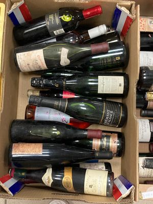 plusieurs bouteilles de vin dans un carton posé sur le sol