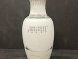 a white vase with oriental writing on it sitting on a table
