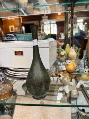 a glass shelf with a vase on it in a store