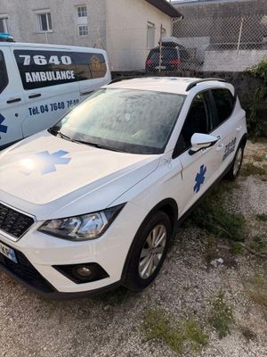 a white car that is parked in front of an ambulance