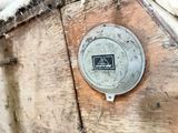a metal plate on the side of a wooden wall