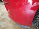 a close up of a red car that is parked in a garage