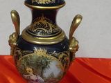 a vase with a lid sitting on an orange cloth