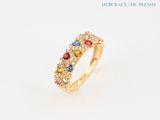gros plan d'une bague en or avec des pierres multicolores