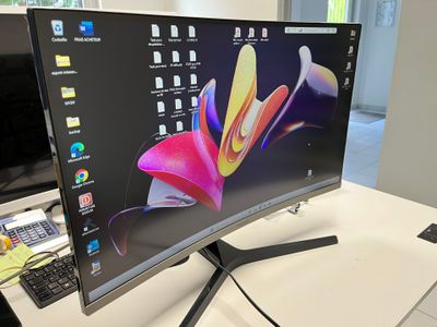 a computer monitor sitting on a desk with a keyboard and mouse
