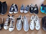Plusieurs paires de chaussures de tennis sont alignées sur une boîte en carton