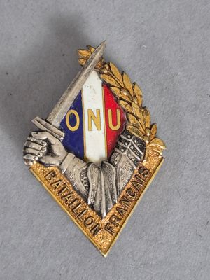 une image représentant un pin's avec une statue tenant une épée