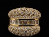 a gold ring with baguets and diamonds on a black background