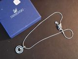 a blue box with a silver necklace and a pair of earrings on it