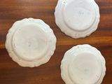 three white plates sitting on top of a wooden table next to each other