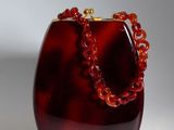une photo d'un sac à main rouge entouré d'une chaîne