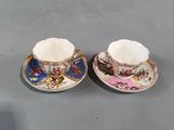 two cups and saucers are sitting on a table next to each other
