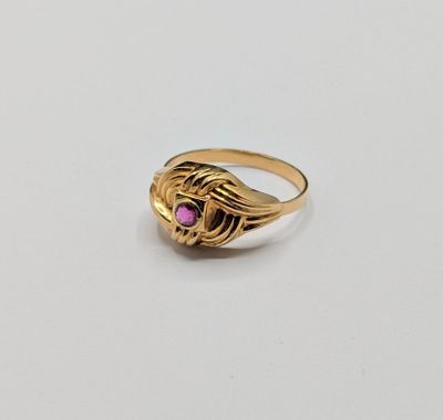 gros plan d'une bague en or avec une pierre rose