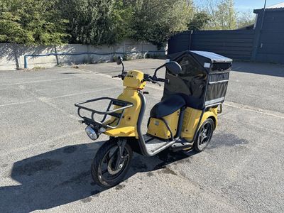 une petite moto jaune avec une selle noire dans un parking