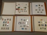 four pages of a book with stamps on them are on a table