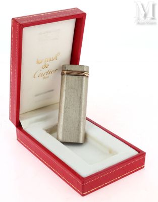 un briquet argenté dans une boîte rouge posée sur une surface blanche