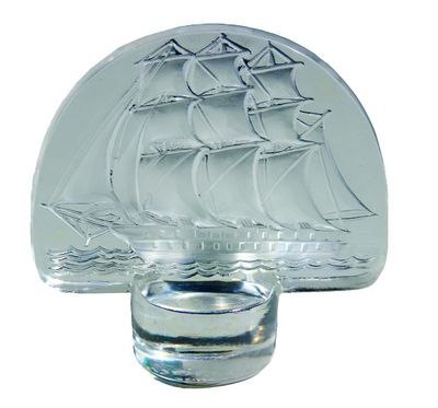 a glass bottle with a ship on it and a shot glass with a shot glass in front of it