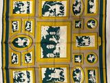 une écharpe carrée verte et jaune sur laquelle figurent un homme et une femme