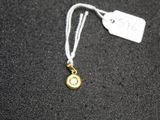 a necklace with a small gold disc on it