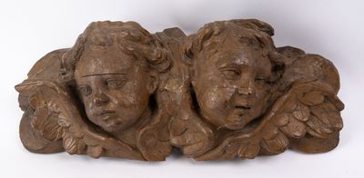 pair of carved wood heads of angels on a white background