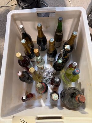 de nombreuses bouteilles de vin dans une glacière posée par terre