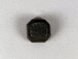 un gros plan d'un petit objet noir sur une surface blanche
