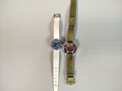 deux montres posées sur une surface blanche