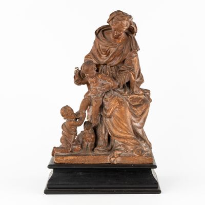 an antique bronze statue of a woman with a child and a dog