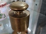 une vitrine en verre sur laquelle est posée une théière en laiton