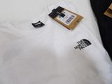 the north face logo t - shirt in white and black on a table